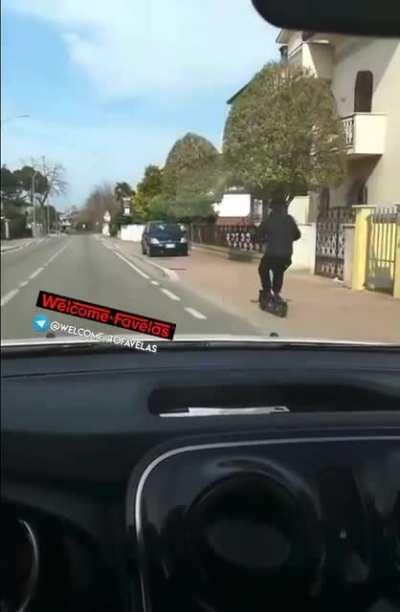 Guy loses control of his scooter and crashes with his head on a parked car