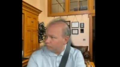 Ohio State Senator, using a Zoom background of his home office while driving, debating a bill for harsher penalties for distracted driving.