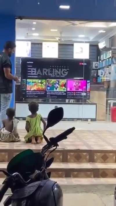 Store incharge let's homeless street kids choose what to watch on the display TV every evening.