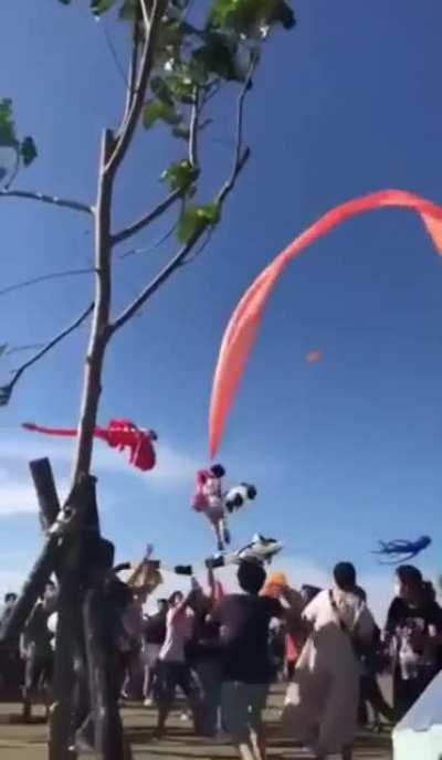 3 year old girl gets caught in a kite and is sent flying during a kite festival in Taiwan