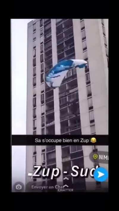 A french guy casually skydives off the top of a building.