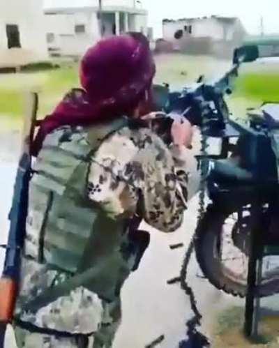 Syrian rebel fighter fires his W85 HMG mounted on a motorcycle towards pro-regime forces. Leg stand has been added to make the platform more stable. Idlib, Syria [Early 2020]
