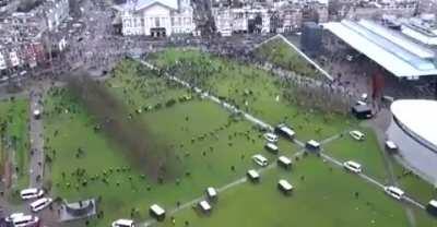 Drone shot of police clearing out protestors from square in Amsterdam