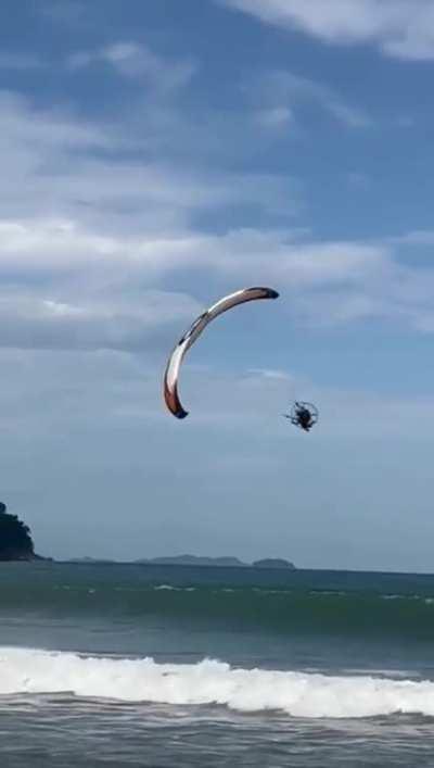 Performing paramotor stunts over a beach