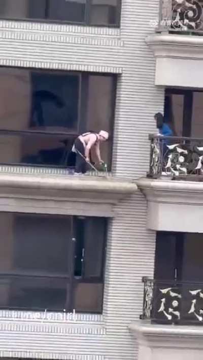 一个敢安排，一个敢干！在没有任何安全措施的情况下在高空做卫生，甚至还拿着水管冲洗。