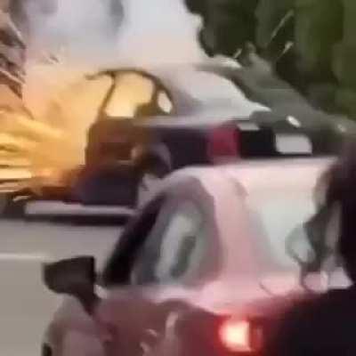 LA rioter lights firework on the street. Gets it thrown back into his car.