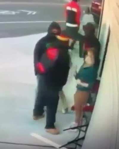 Female store owner standing still beat by frustrated looters