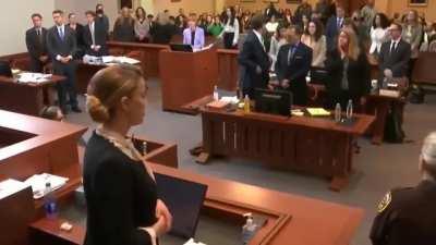 Amber Heard acts scared as Johnny gets close in court with two guards standing between them.