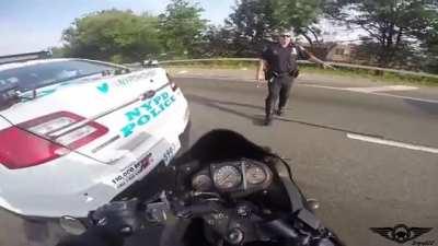 Motorcyclist driving between adjacent rows of vehicle traffic