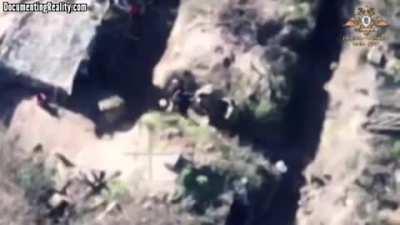 A Russian drone overlooks two Ukrainian soliders fighting whilst their comrades try to break it up.