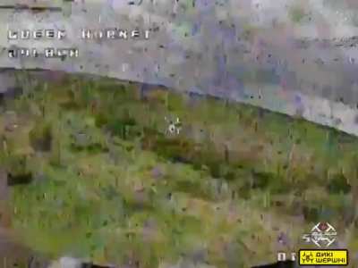 A Ukrainian FPV quad uses an attached grenade launcher during a strafing run to target a Russian soldier and their position.