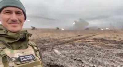 Russian soldier proudly smiling as artillery is firing upon Mariupol