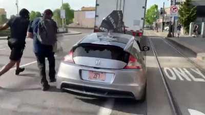 Man escapes violent demonstrators attacking his car