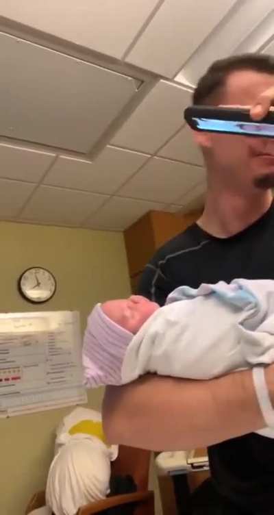 Dad starts crying after holding his new born baby.