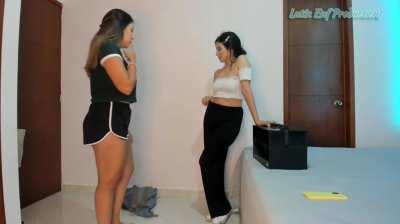 Two girls pantsing each other