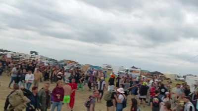 Thousands of people form an insane parade behind a car at 