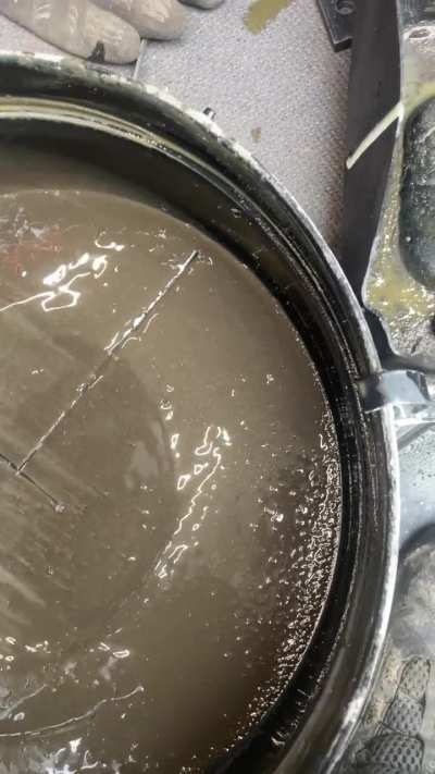 Cleaning out 500h collection of sediment in the  bottom of an oil bath air cleaner on a wheel loader Volvo L260H