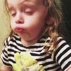 This little girl pretending to enjoy her mum's cooking.