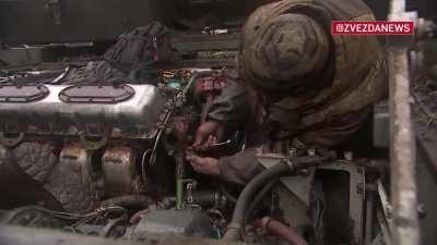 Ru Pov: Russian mechanics repair/service military equipment outside in the open