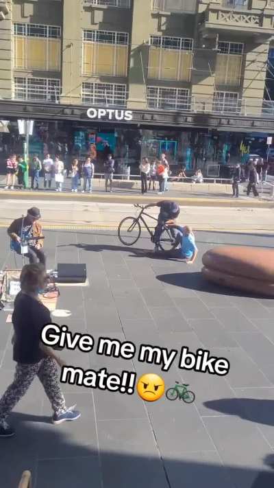 Two men fighting over a bike in Melbourne CBD.