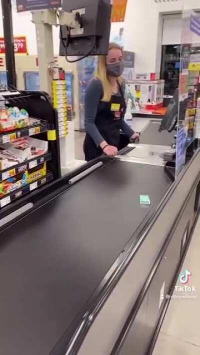 Cashier waiting on Tictacs to go all the way down the conveyor belt
