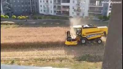 Polish farmer who refused to sell his land to developers harvests his field surrounded by apartments