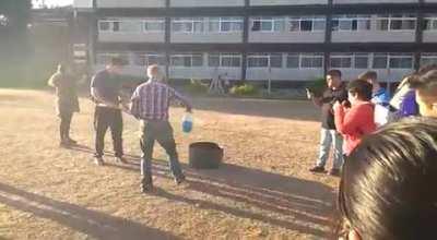 My teacher lighting the fire for fire extinguisher training