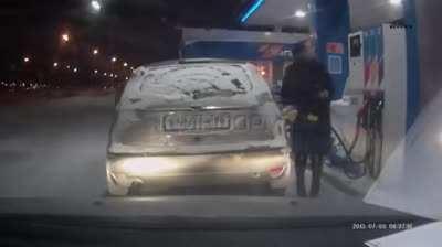 Using a lighter to see the gas pump nozzle