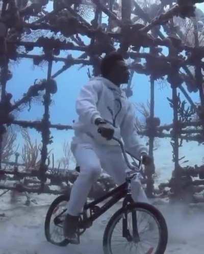 Man Takes Off Scuba Gear to Pose on BMX Bike Under Water.