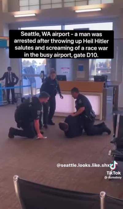 Man in an airport does the the Sieg Heil