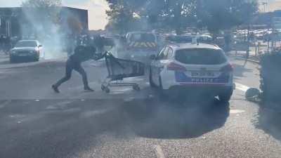 Idiot fighting a French police car with a cart