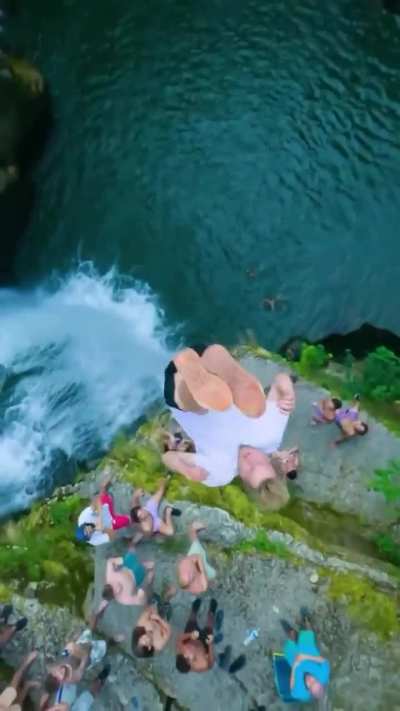 Stunning jump into a waterfall basin 