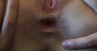 A woman spreading a lesbian's asshole