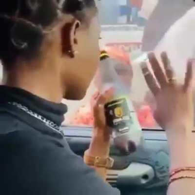 Nigerian social media influencer teasing a child beggar with a bottle of drink