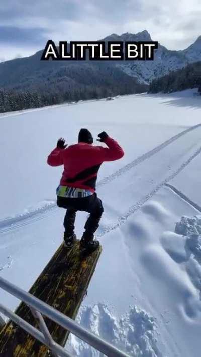 guys jumping into snow from a crane