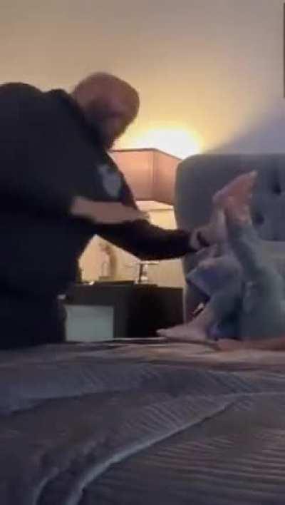 Dad wrestling with his two kids on the bed