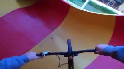 This maniac riding a BMX bike down a water slide at an abandoned waterpark