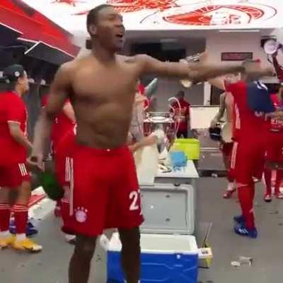 Odriozola polishes the UCL trophy as everyone celebrates.