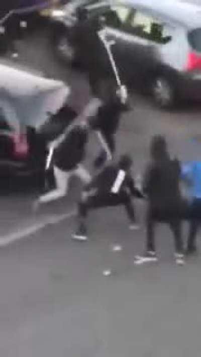 Gang beats someone up with pole-based weapons