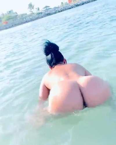 Asian stripper frolicking in the waves.