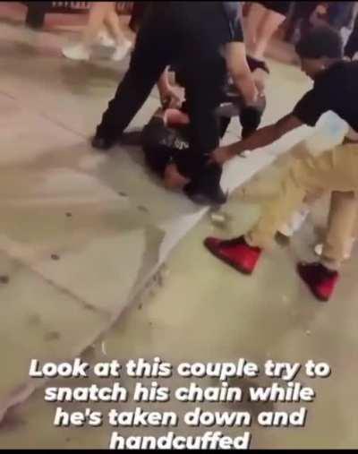Trying to snatch his chain when he’s handcuffed