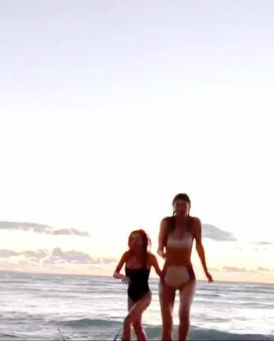 Alexandra Daddario and Sydney Sweeney running on the beach together