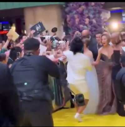 Cynthia Erivo protects Ariana Grande from a fan running onto the carpet at the wicked for good premier