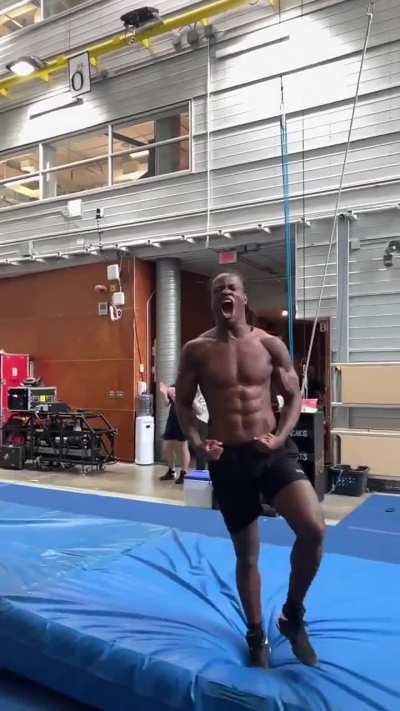 Super athlete gymnast jumping over suspended rings