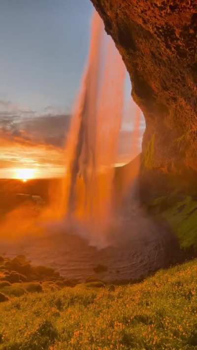 Seljalandsfoss is one of Iceland's most iconic waterfalls situated along the south coast, is the result of the Seljalandsá River cascading dramatically over a cliff's edge.What sets it apart from other waterfalls is the unique opportunity to stand directl