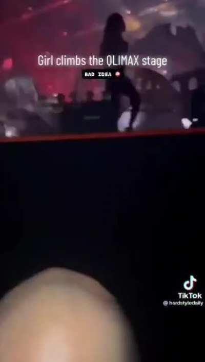 Girl climb on huge stage during a hardstyle event and falls off