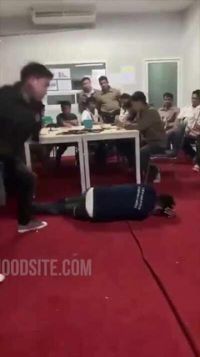 This employee, in the Philippines, violated some policy and receives coaching so that they won't make the same mistake again. His colleagues watch so as to learn from the mistake.