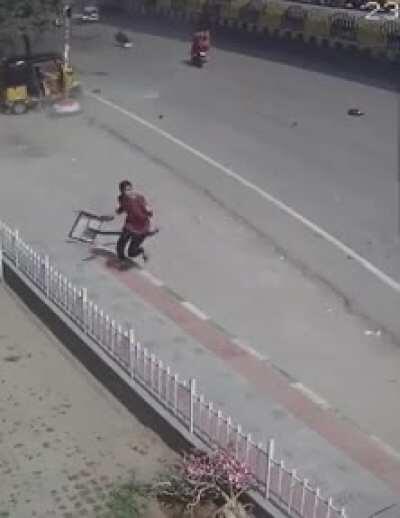 Woman avoids getting hit by a sign because of a car falling from the sky