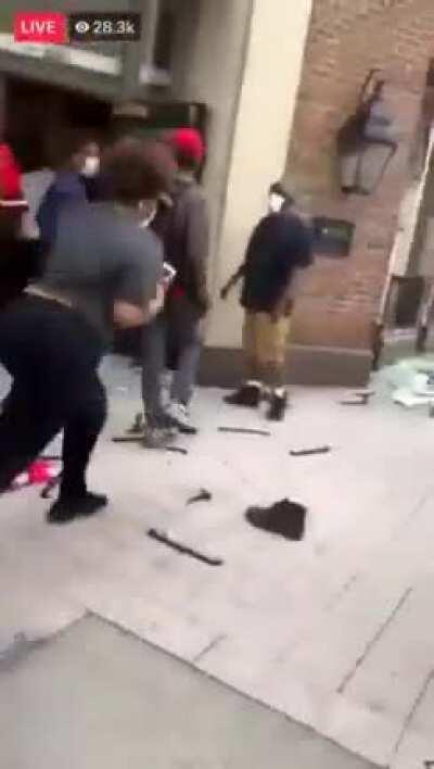 Woman parks her nice car in the middle of a busy street to stop and join looters and picks up a couple pairs of free shoes