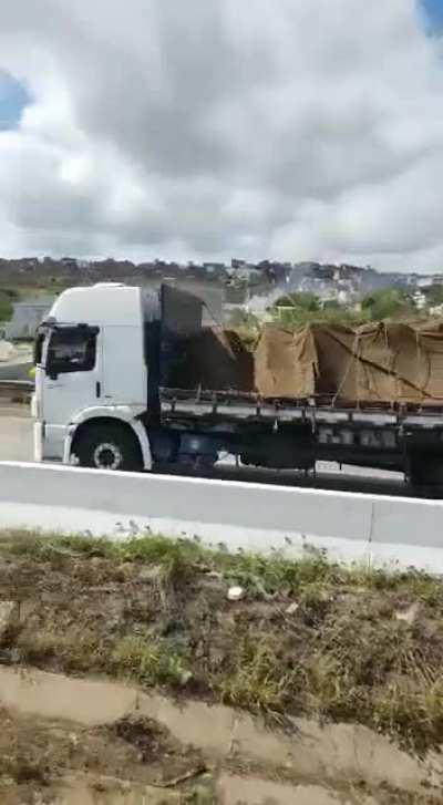 Man being carried by a truck on a highway -Brazil (context in comments)